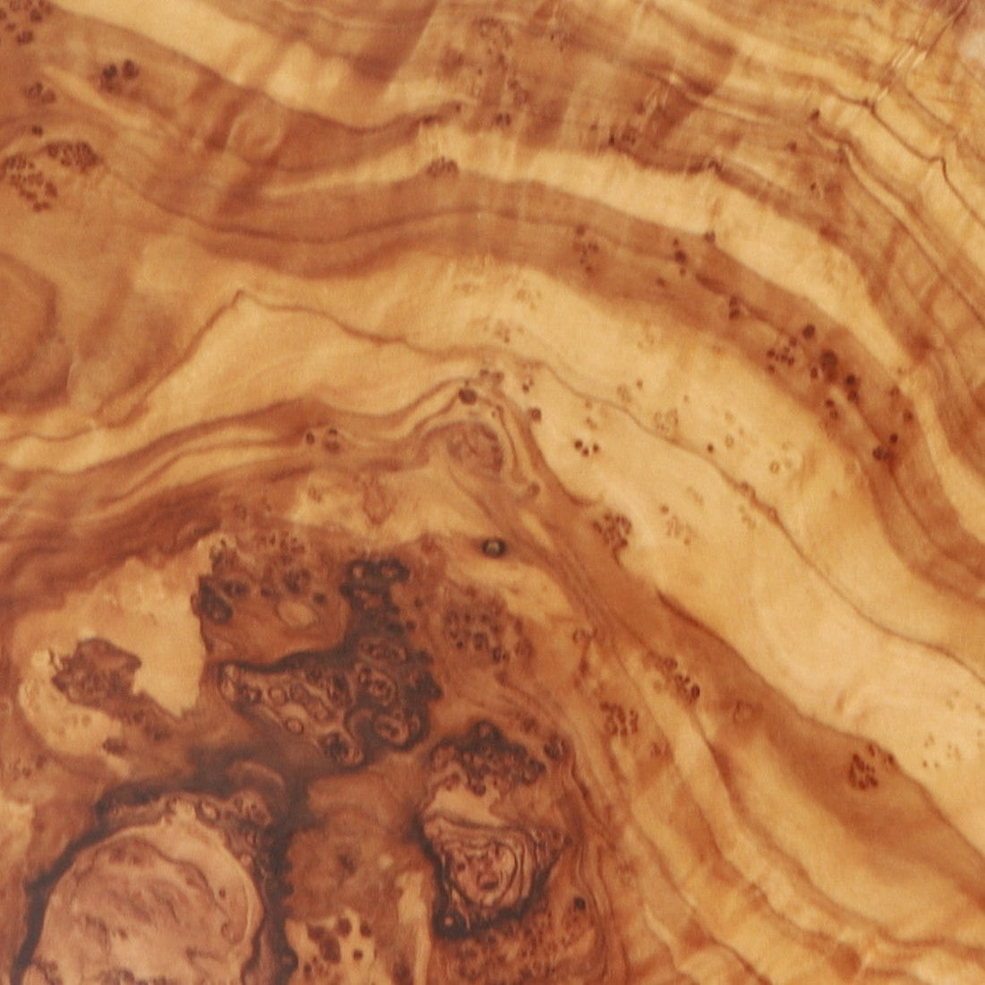 Close-up of natural olive wood grain showing the swirling pattern unique to each handcrafted piece