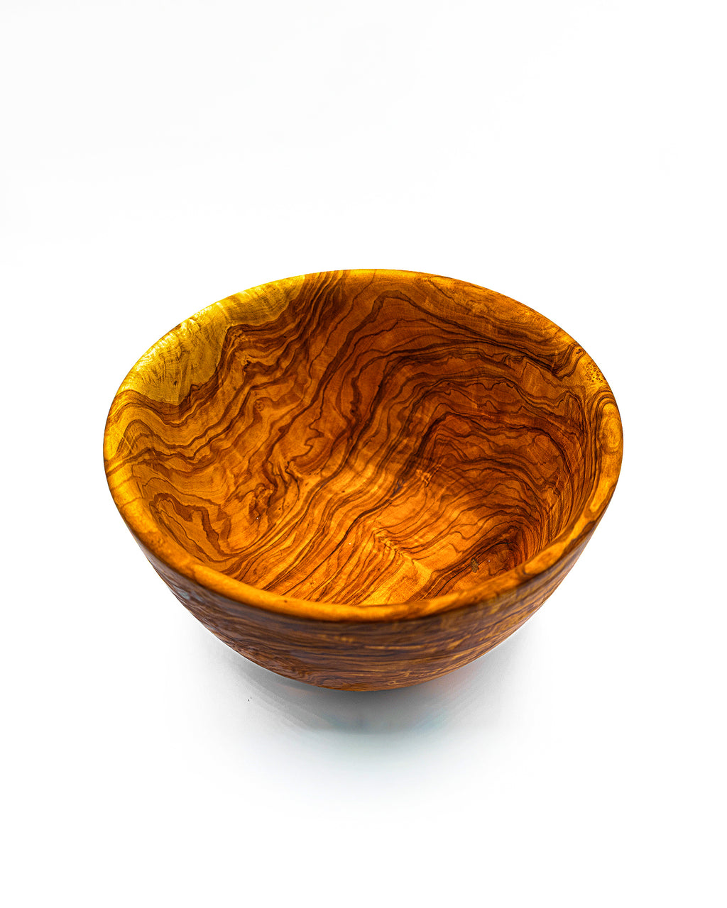 A perspective view of an artisan olive wood bowl, ideal for serving salads or used as a decorative fruit bowl on a kitchen island.