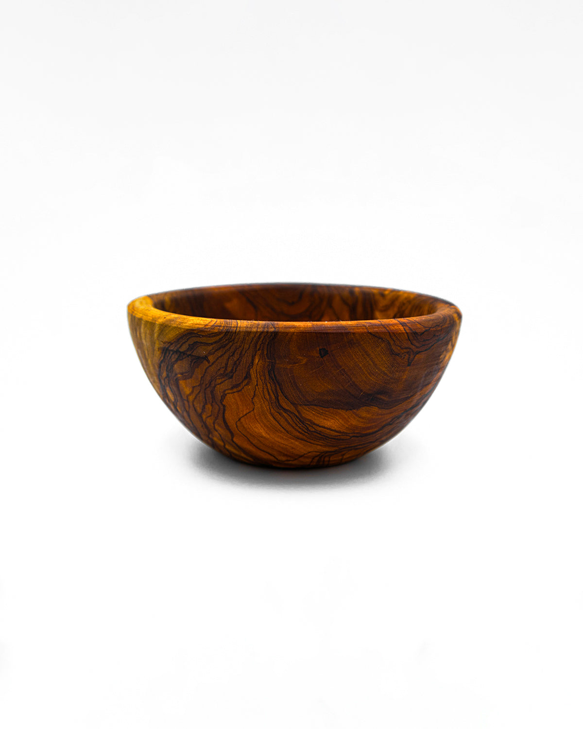 Low angle shot of a hand-carved olive wood dipping bowl on a white background, perfect for rustic kitchen decor.