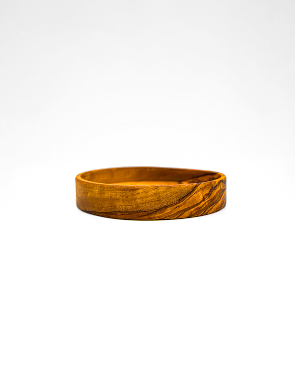 Wide profile of a hand-carved olive wood sauce dish on a white background, highlighting its low-profile design.