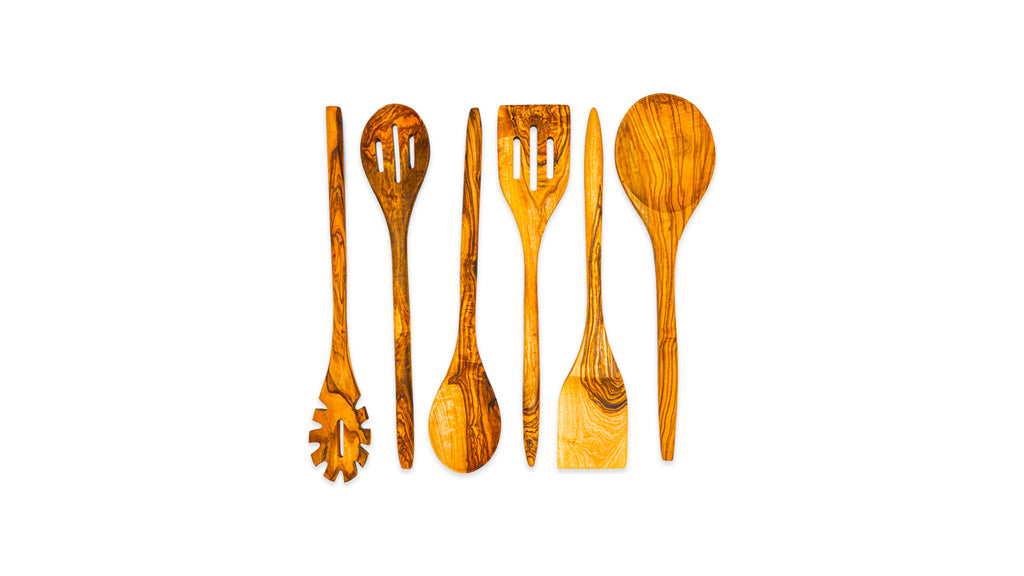A top-down lineup of a 6-piece olive wood cooking set including a pasta fork, slotted spoon, solid spoon, slotted turner, flat spatula, and large serving spoon.