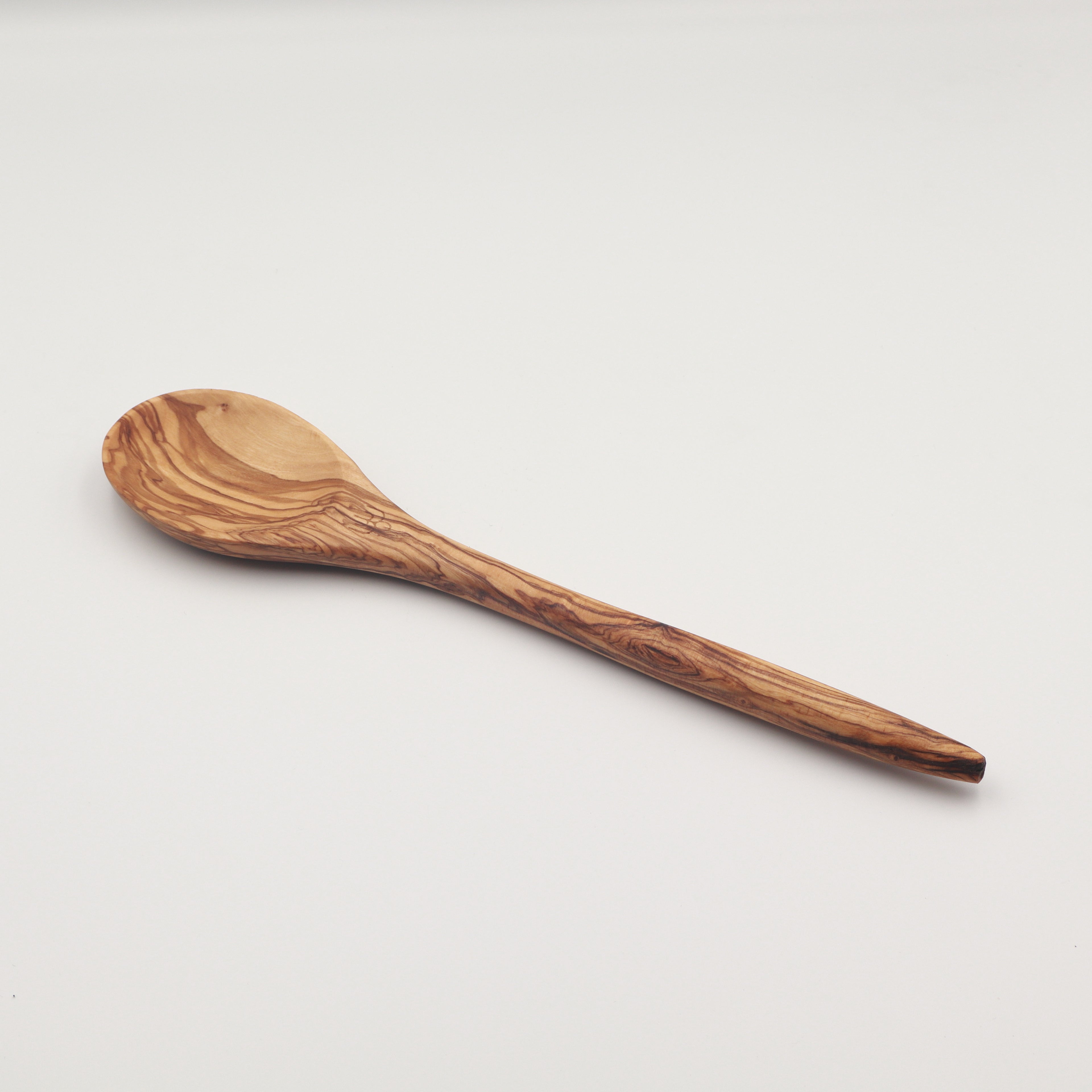 Handcrafted Tunisian olive wood cooking spoon with a tapered handle, shown on a white background highlighting the natural grain.