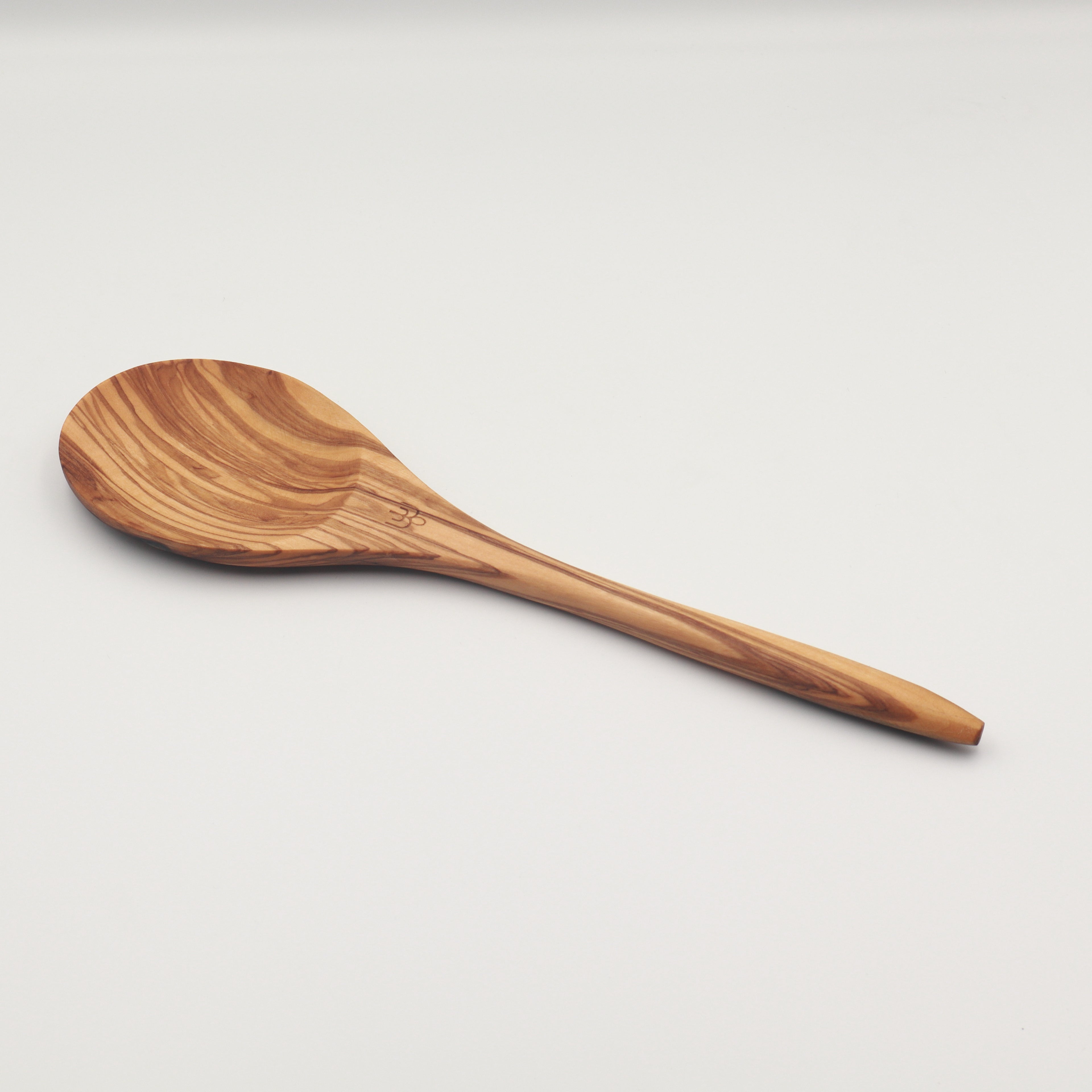 Handcrafted Tunisian olive wood mixing spoon shown on a white background, featuring the Willow & Spoon engraved mark.