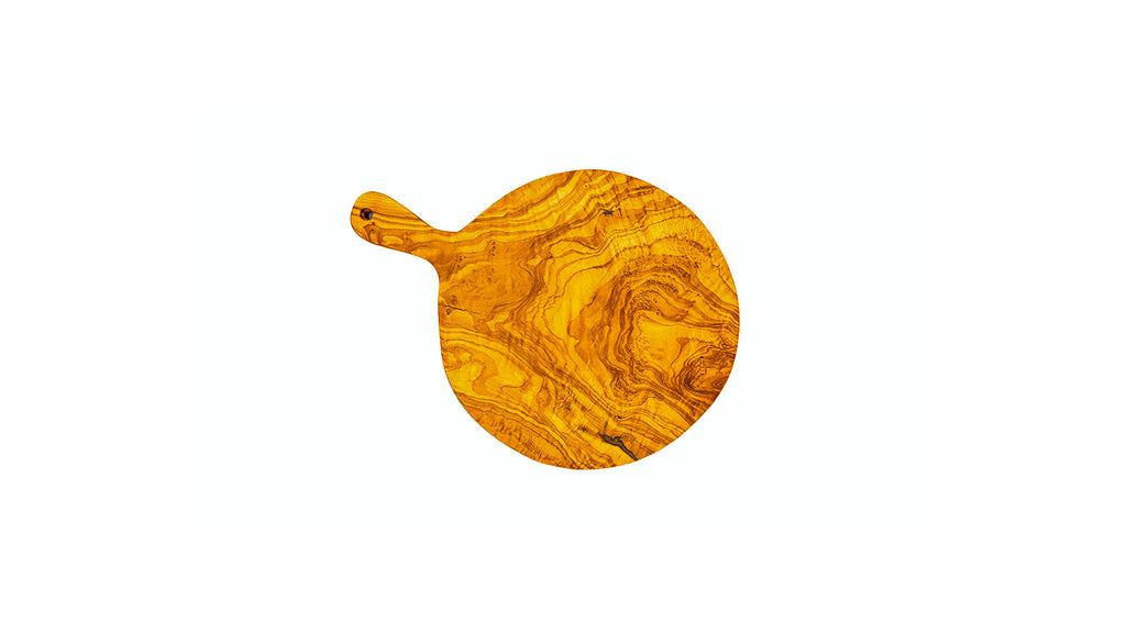 Top-down view of a circular olive wood pizza board and cheese paddle, showing the expansive artisan wood grain.