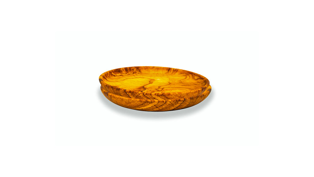 Side view of two stacked handcrafted olive wood appetizer plates showing the natural curved edge and unique wood grain texture.