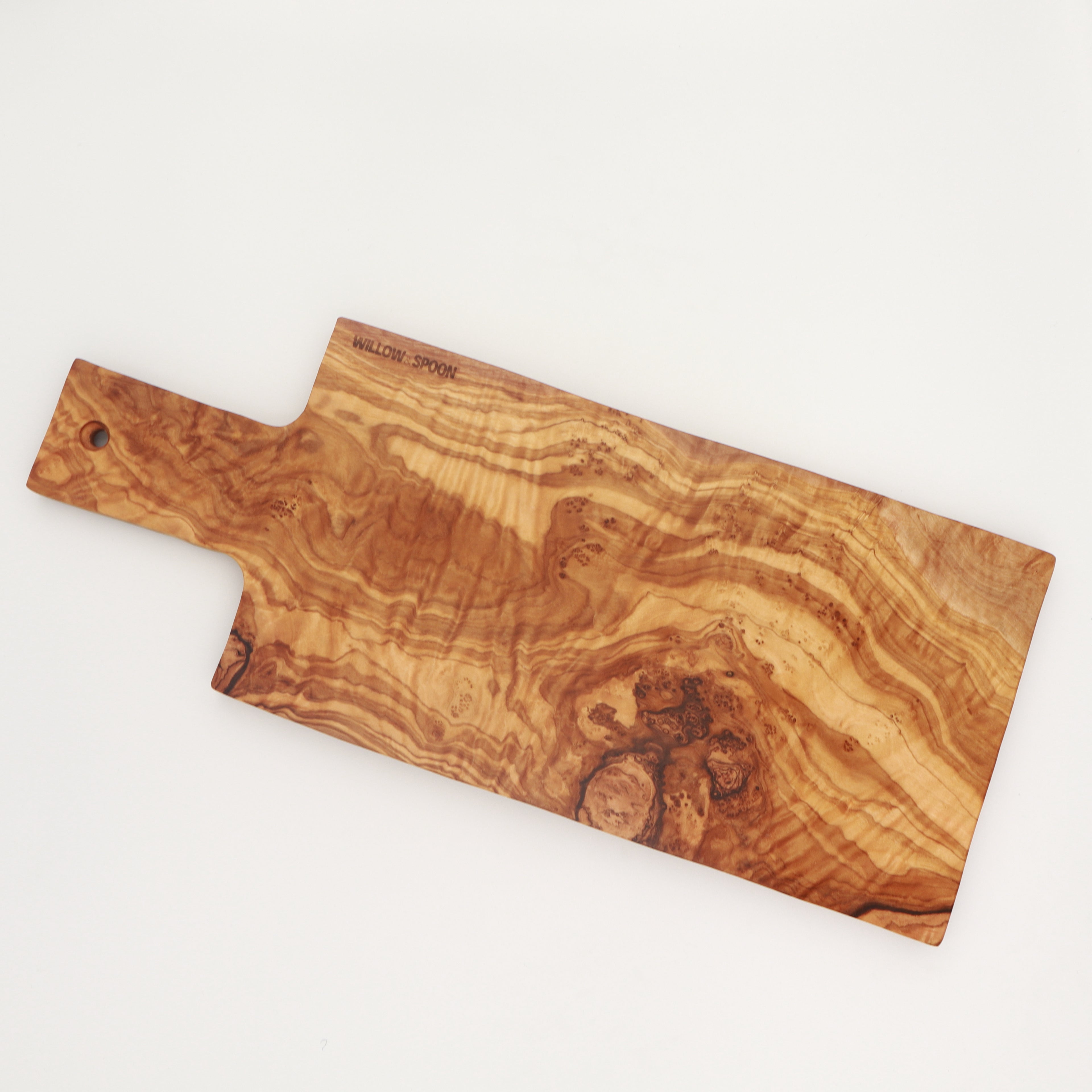 Overhead view of a handcrafted Tunisian olive wood rectangular cutting and serving board with handle, featuring the Willow & Spoon engraved mark on a white background.