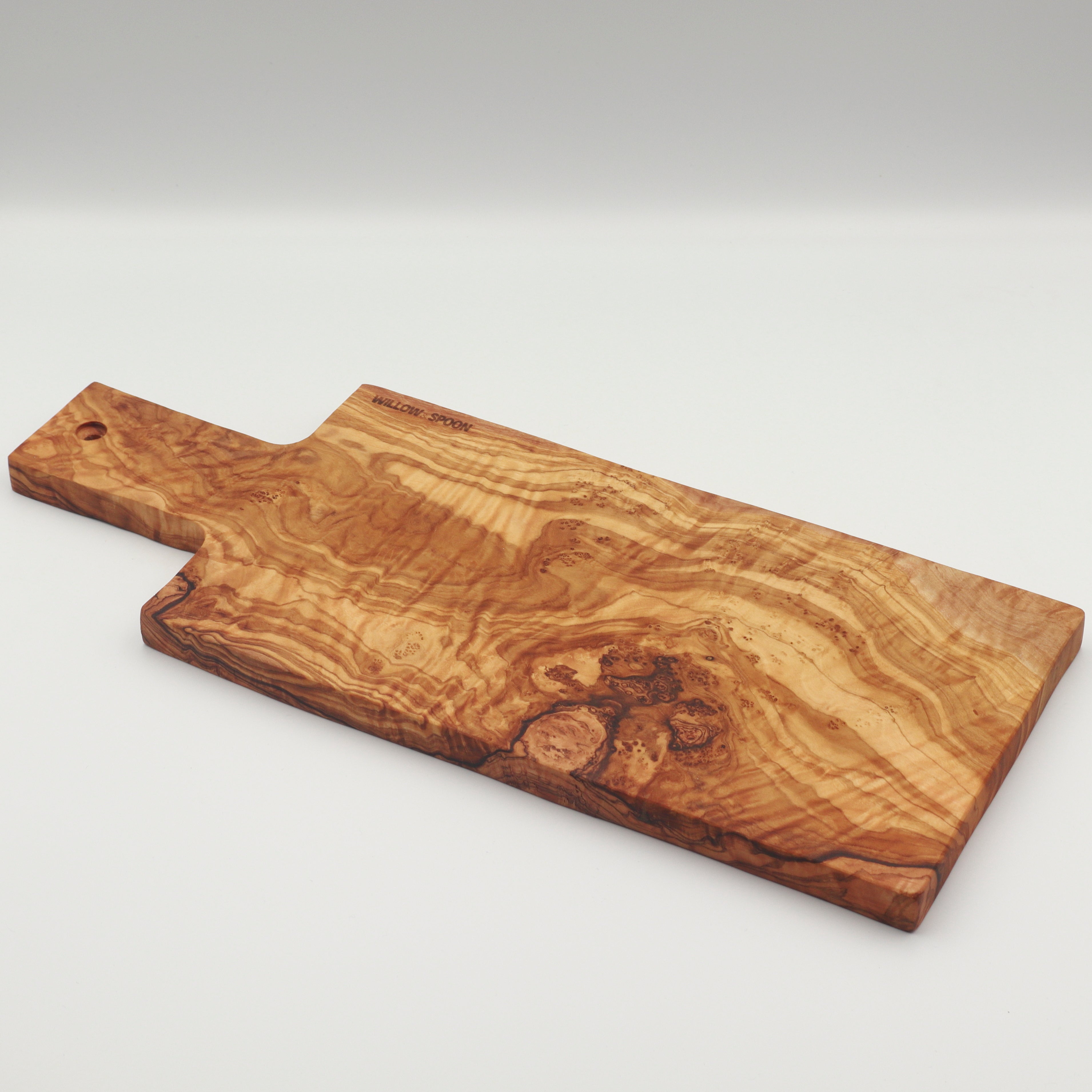 Handcrafted Tunisian olive wood rectangular cutting and serving board with handle on a white background, featuring the Willow & Spoon engraved mark.