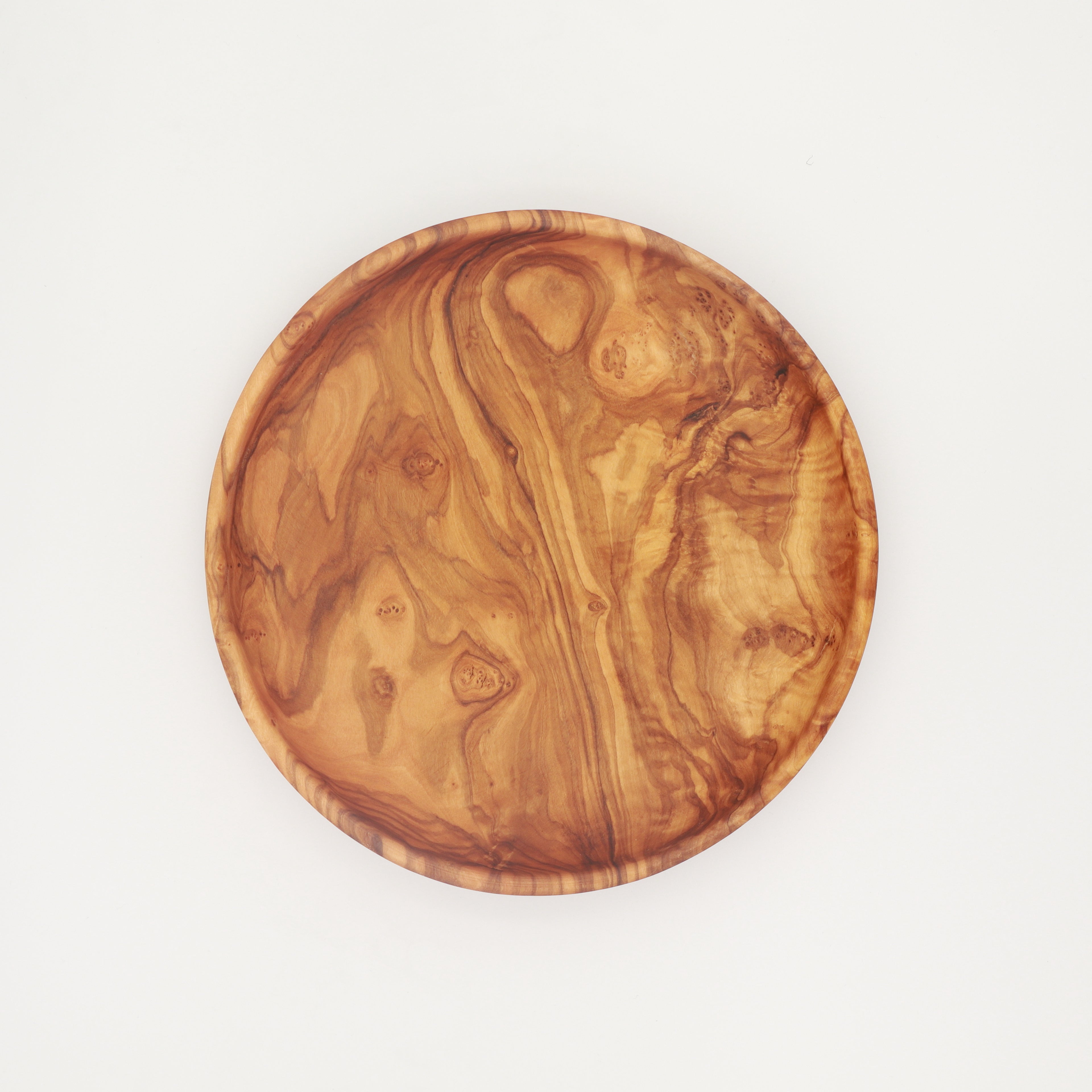 Single handcrafted Tunisian olive wood round plate viewed from above, showing distinctive grain patterns on a white background.