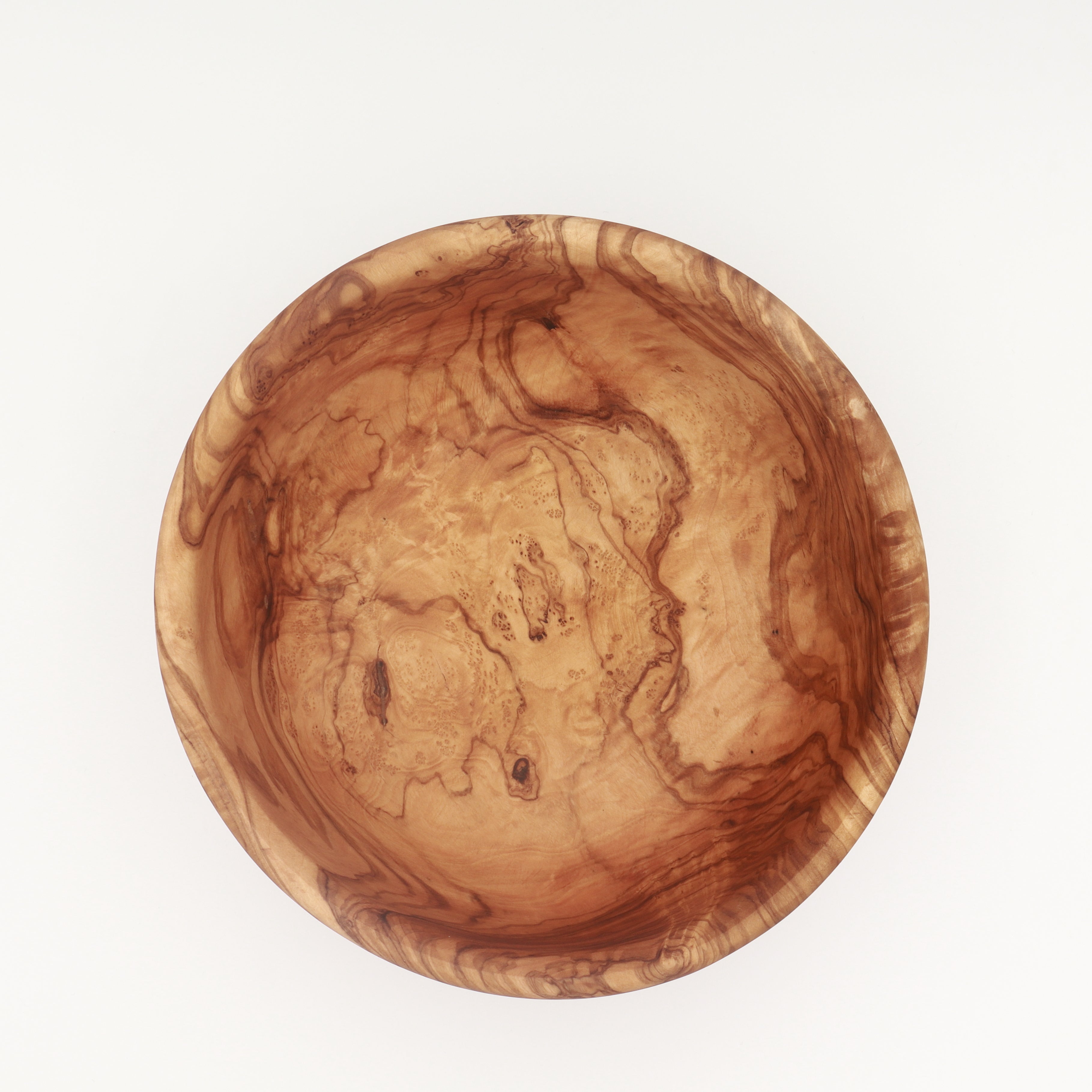 Overhead view of a handcrafted Tunisian olive wood salad bowl showing the interior grain on a white background.