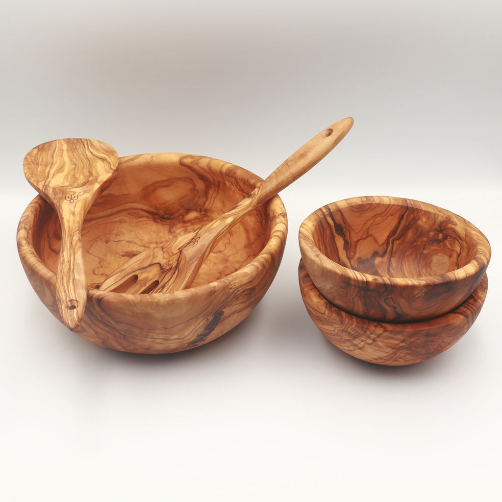Handcrafted Tunisian olive wood salad set with large serving bowl, salad servers, and two stacked side bowls on a white background.