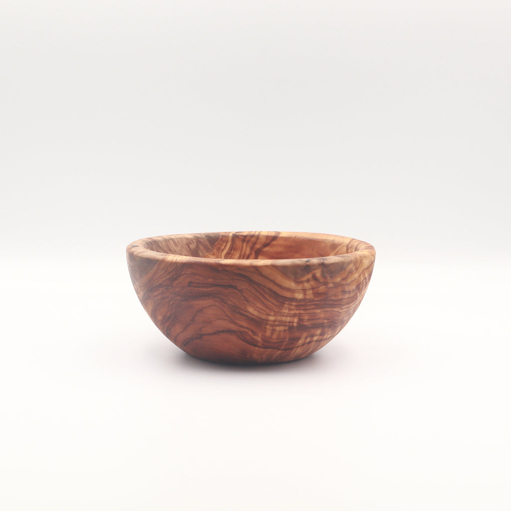 Side view of a single handcrafted Tunisian olive wood small bowl on a white background highlighting the natural grain.