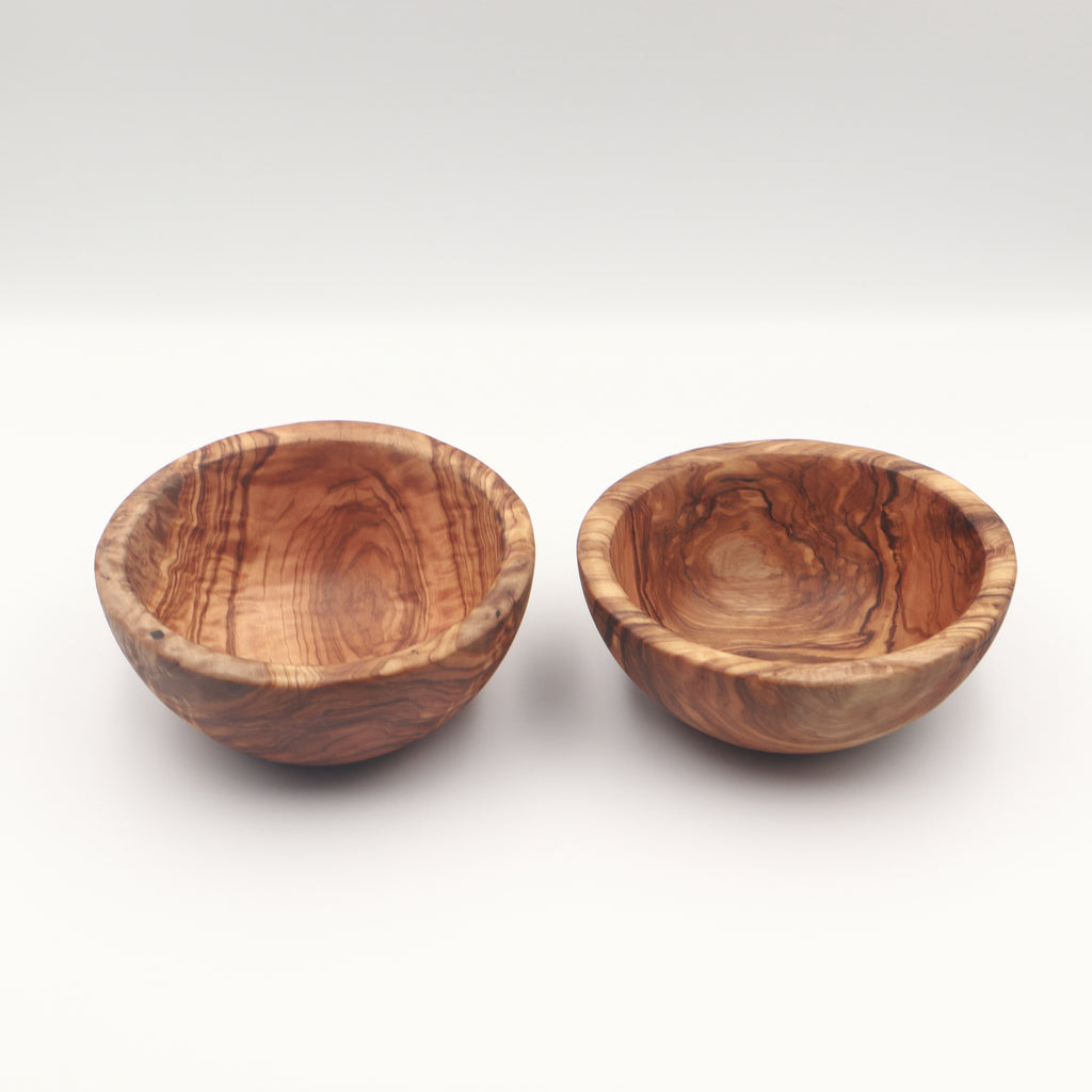 Two handcrafted Tunisian olive wood small bowls side by side, shown on a white background highlighting the natural grain.