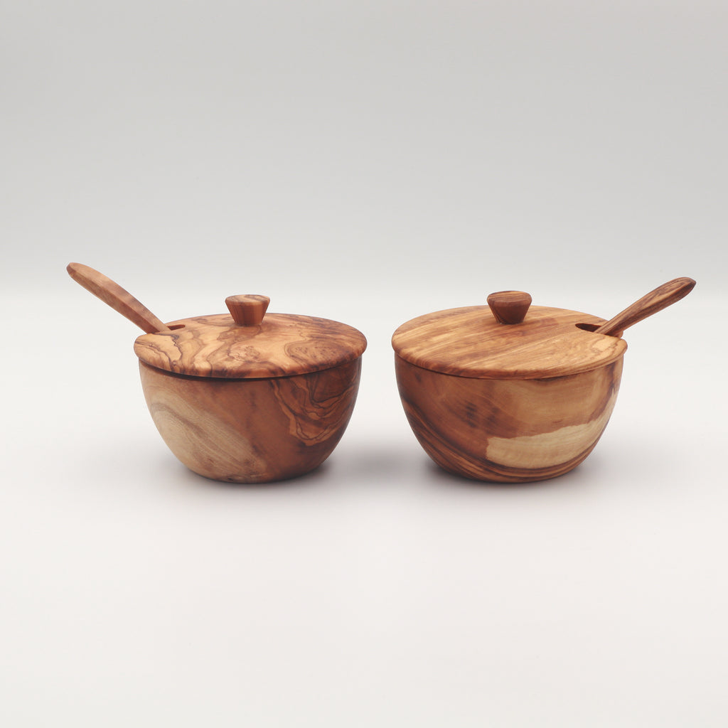 Pair of handcrafted Tunisian olive wood spice boxes with lids and serving spoons on a white background.