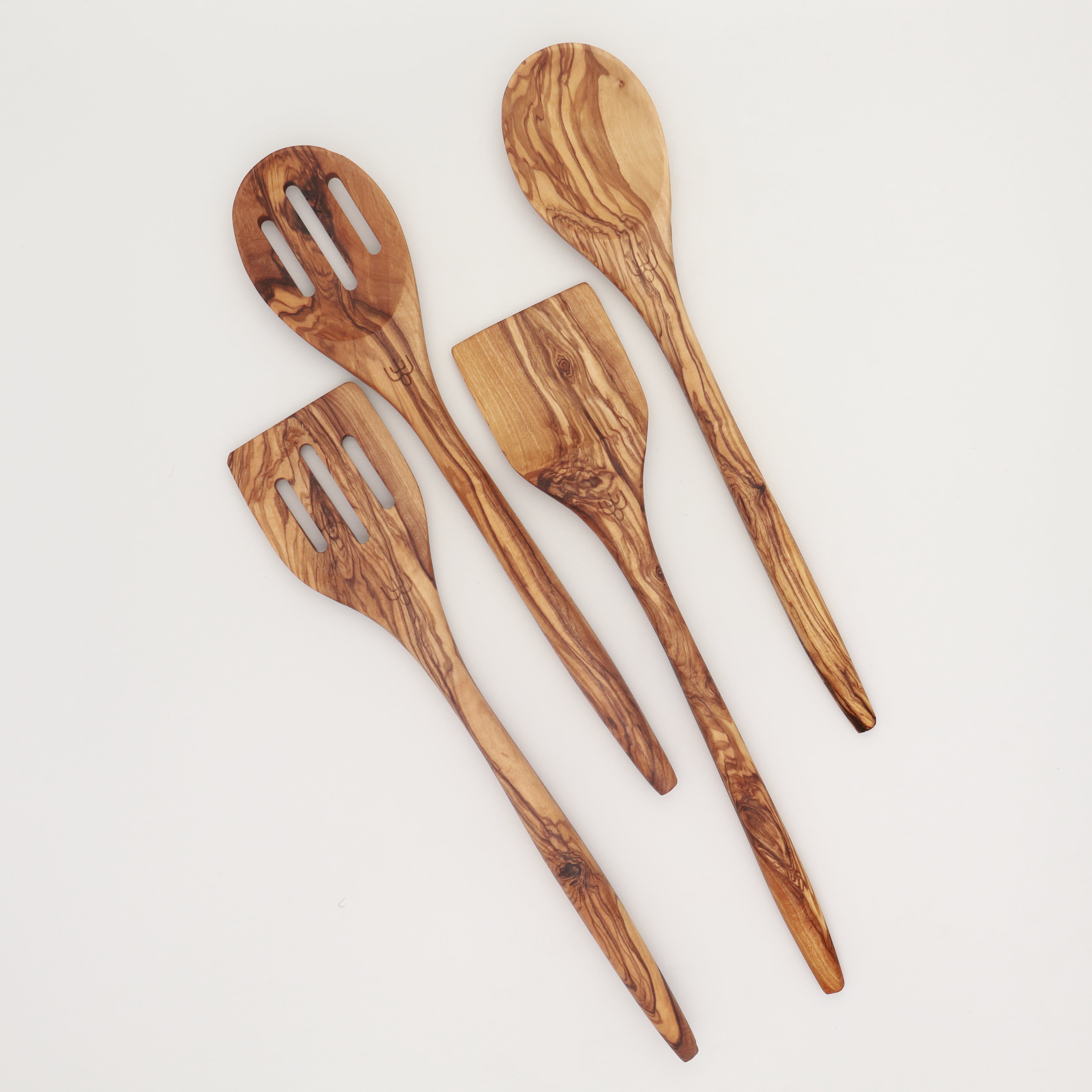 Handcrafted Tunisian olive wood four-piece utensil set with slotted spoon, slotted spatula, spatula, and mixing spoon arranged on a white background.