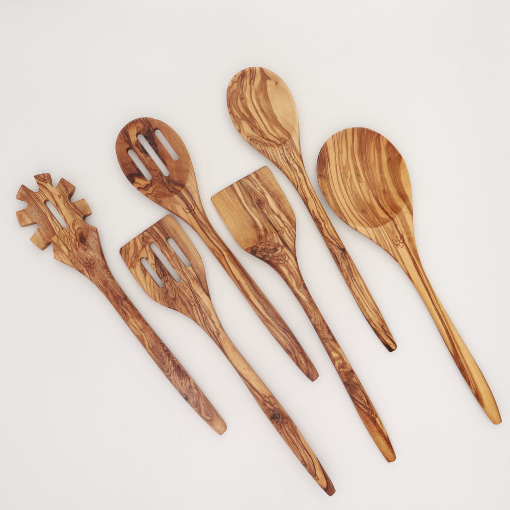 Handcrafted Tunisian olive wood six-piece utensil set including pasta server, slotted spoon, spatula, and cooking spoons on a white background.
