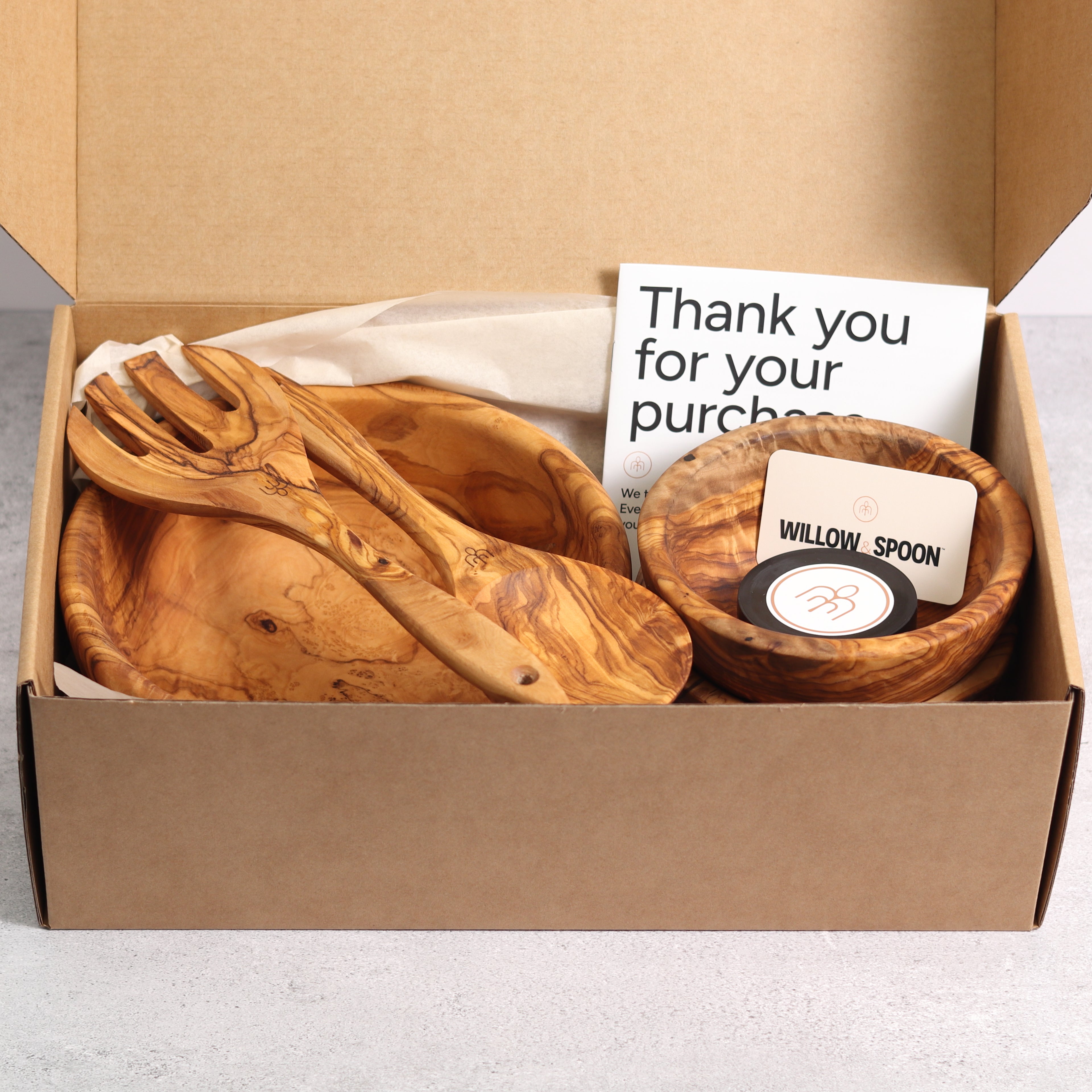 Olive wood salad bowl with servers and two small bowls packaged in a Willow & Spoon gift box with tissue paper, branded coaster, and thank you card