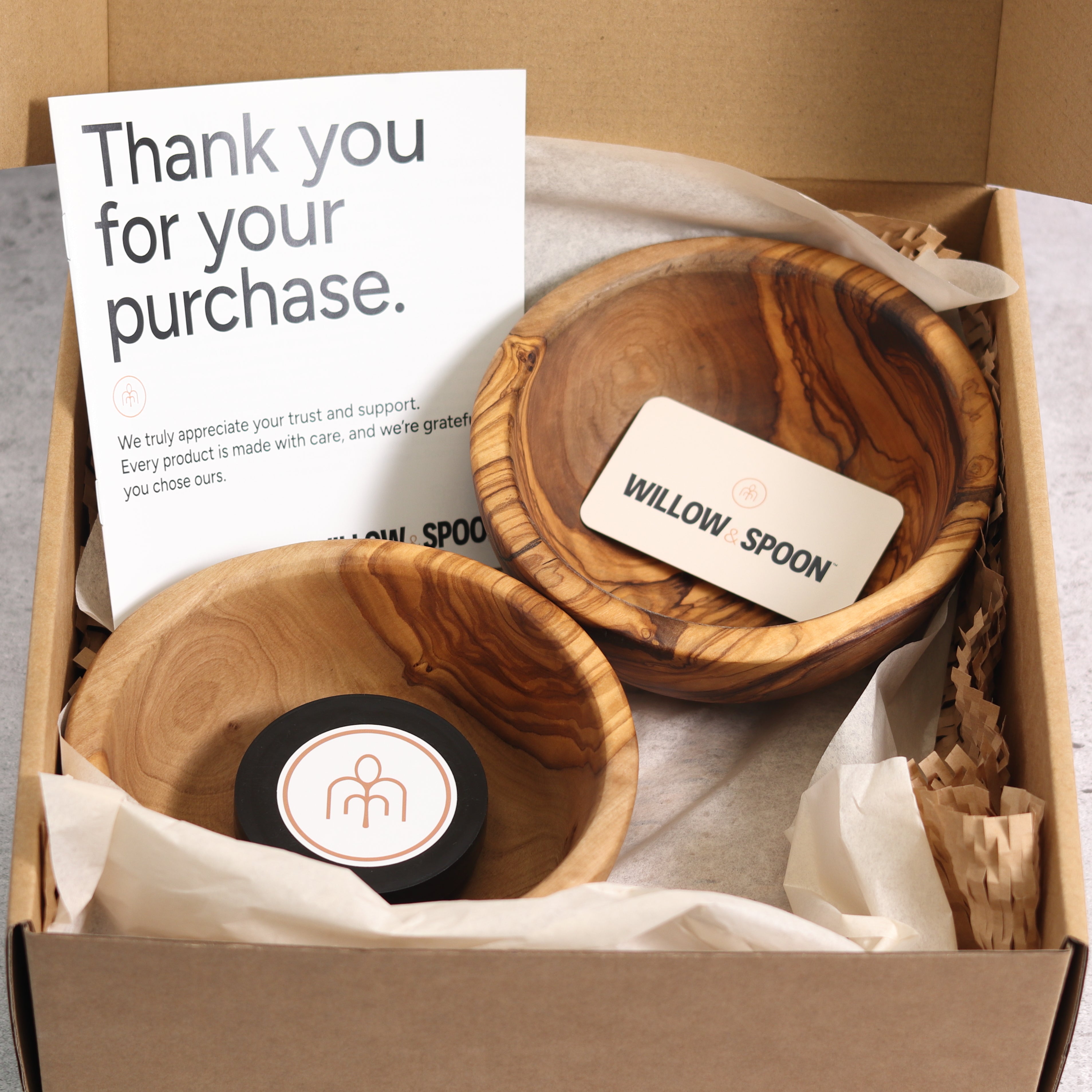 Two olive wood bowls packaged in a Willow & Spoon gift box with tissue paper, branded coaster, and thank you card